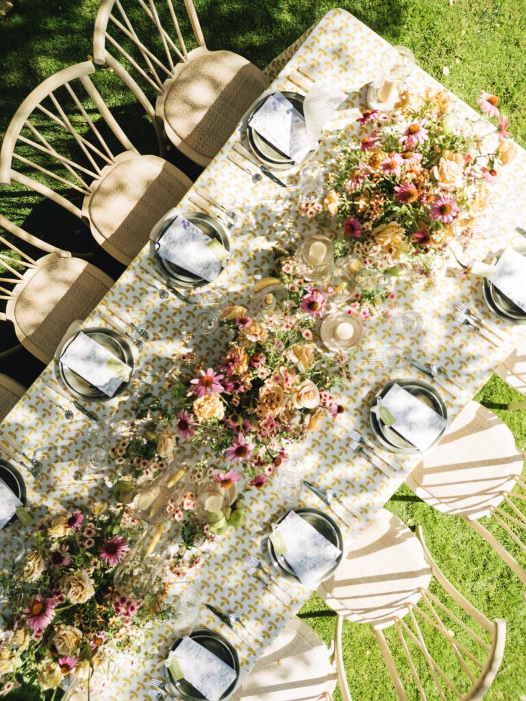 Maximalist outdoor wedding tablescape at Holman Ranch in Carmel Valley with yellow embroidered BBJ La Tavola linens, organic floral centerpieces by Amy West Floral, and vineyard garden backdrop.